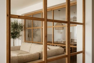 Verrière intérieure en bois chêne séparant salon et salle à manger dans un appartement contemporain